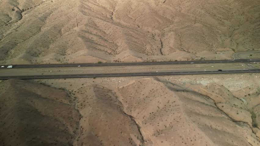 Aerial tilt down on divided highway in Arizona desert near Lake Mead