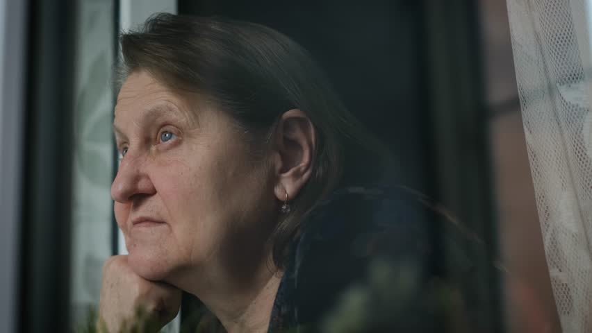 Sad elderly lonely woman looking out the window, close up Royalty-Free Stock Footage #1110810351
