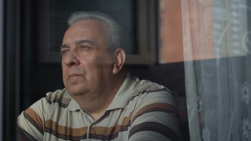 Sad elderly lonely gray-haired man looking out the window, close-up Royalty-Free Stock Footage #1110810361