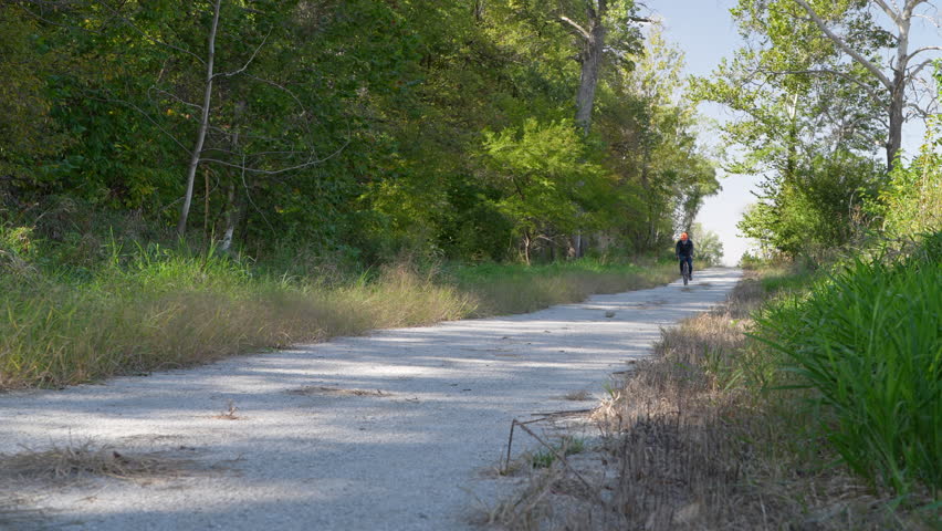 senior male cyclist on a gravel bike riding Steamboat Trace Trail in Nebraska near Peru, the trail is converted from old railroad running along the Missouri River 