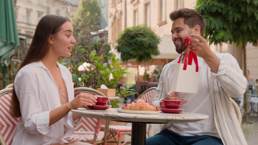 Happy European couple man gives woman a gift surprise anniversary celebration emotions city outdoors cafe together tender love feelings sm ling laughter romance relationship married family enjoy care Royalty-Free Stock Footage #1110811207