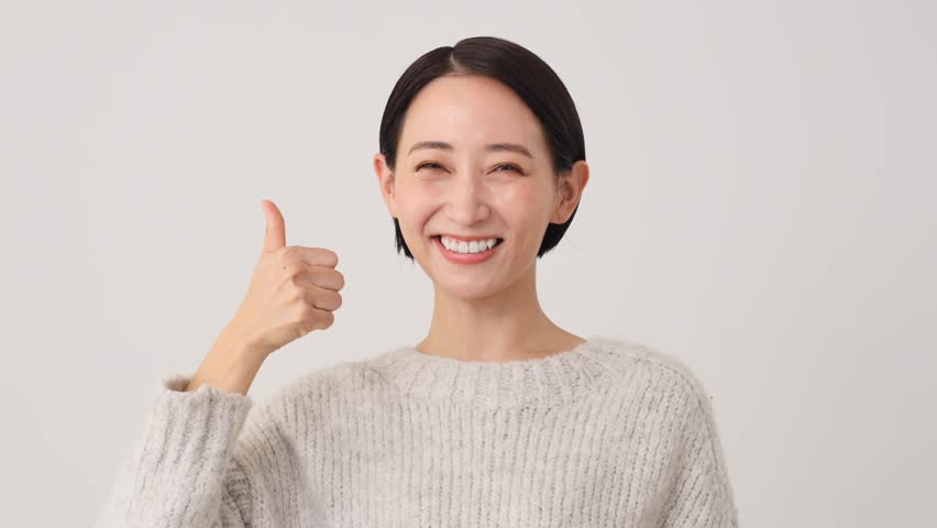 Asian middle aged woman thumbs up gesture in white background Royalty-Free Stock Footage #1110815789