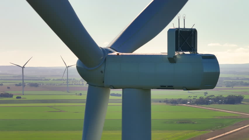 Aerial tracking shot of front of wind turbine in Southwest Victoria, Australia.