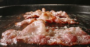 Frying halal beef bacon in pan side view close up slow motion. Traditional breakfasts bacon comforting morning rituals. Crispy bacon crunchy addition elevates dish delights taste buds with every bite