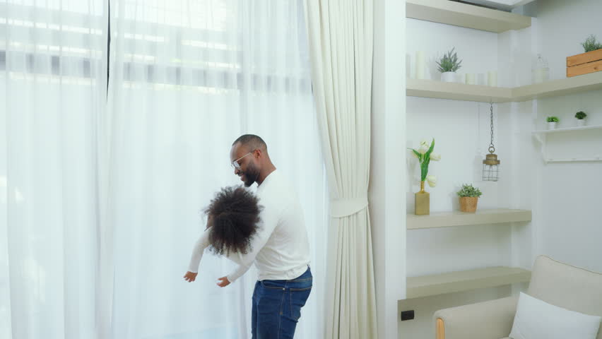 Happy african family parents and little children enjoy together and relaxing couple with kids having fun at home