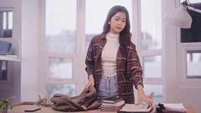Asian schoolgirl student in casual attire is carefully organizing her textbooks according to her class schedule, placing them inside her school bag. She's doing this task in her dorm room - Powered by Shutterstock - Get 15% off with code: PIKWIZARD15