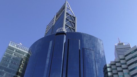 Upward view of modern office building in city business district or CBD Perth, Western Australia, blue sky as background, copy space, move left to right
