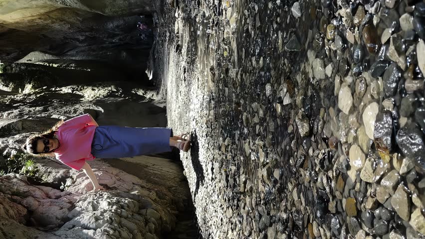 a girl walks in the mountains, a woman travels, a girl walks near the rocks, vertical video shooting