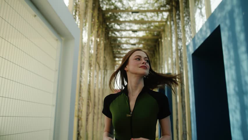 Sporty young girl in sportswear and headphones running in the park. Sport, workout, fashion, lifestyle concept.