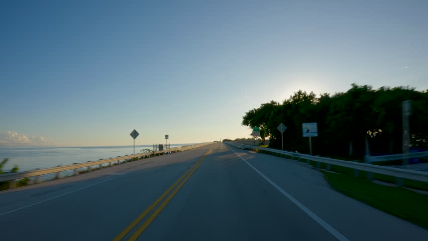 POV Driving a car towards sunset on Overseas Highway Bridge Florida Keys
