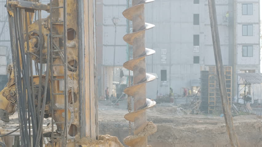 Equipment for installing piles in ground, heavy machines for driving pillars work in laying the foundation building. Construction aerial view height. Construction site drilling pile foundation. Royalty-Free Stock Footage #1110841121