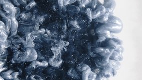 Vertical video. Ink splash background. Explosion cloud. Hypnotic steel gray glitter burst smoke swirls spreading in dynamic abstract art on white.