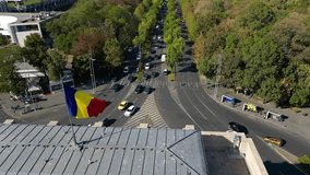 Aerial drone footage of the Free Press Square viewed from the Arcul De Triumf square in the capital of Romania - Bucharest. Kiseleff road seen from the air. Aerial video. Flag of Romania