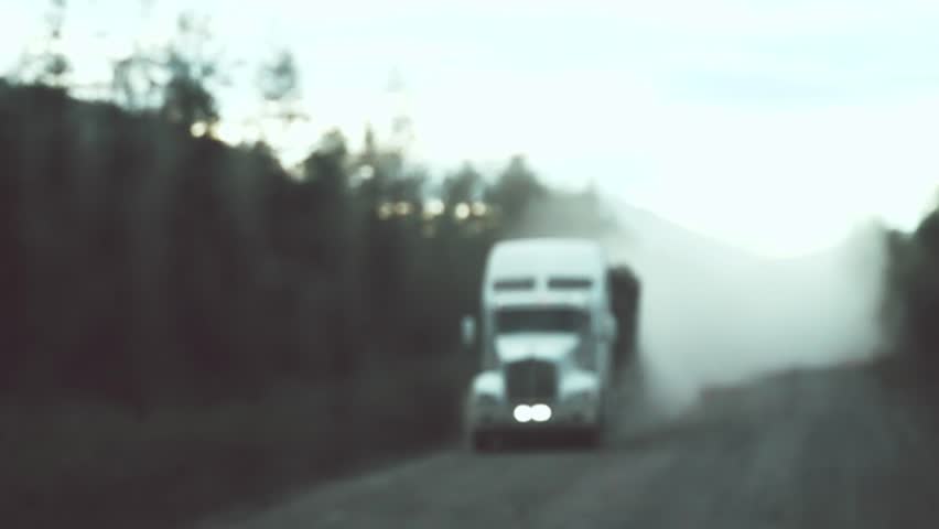 This is famous Magadan Highway - embankment dirt road built by prisoners of concentration camps of 30-th through taiga and swamps. Trucks move in clouds of dust. Siberia. Super slow motion 1000 fps