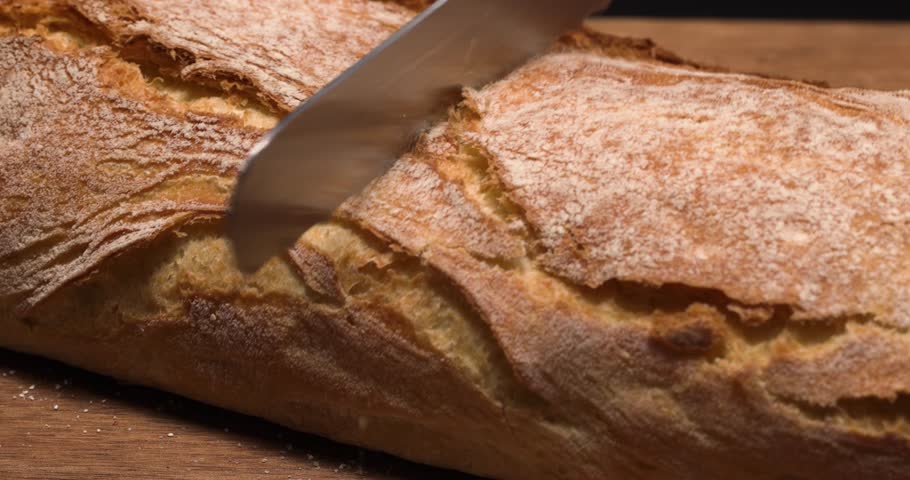 Knife cutting through Italian white bread