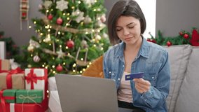 Young caucasian woman doing christmas online shopping with laptop at home - Powered by Shutterstock - Get 15% off with code: PIKWIZARD15