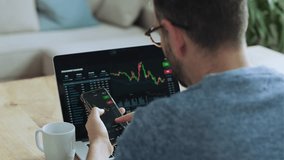 Businessman looking at smartphone and laptop with stock market charts - Powered by Shutterstock - Get 15% off with code: PIKWIZARD15