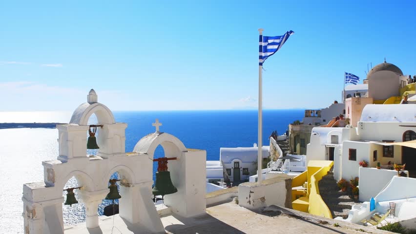 Santorini island, Greece. Traditional greek architecture in Oia town. Blue sea and the blue sky at sunny day. Travel and vacation. Zoom out
