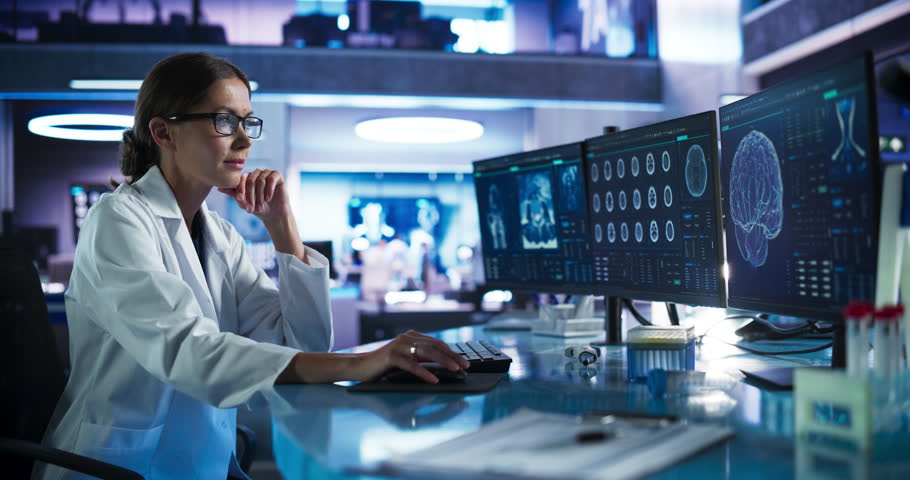 Medical Hospital Research Laboratory: Caucasian Female Neurosurgeon Using Computer with Brain Scan MRI Images, Finding Best Treatment for Sick Patient. Health Care Neurologist Analysing MRI Scan.