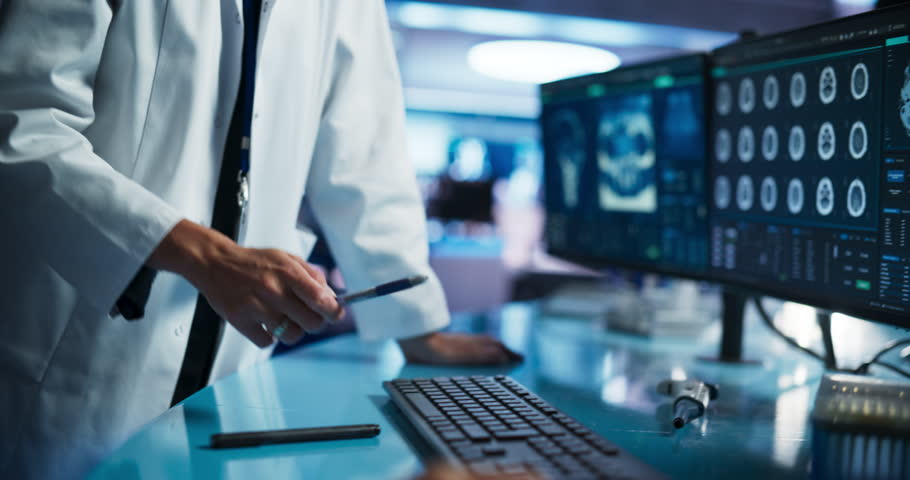 Modern Medical Research Center: Anonymous Doctor Pointing At Desktop Computer Monitor With CT Scan Of Human Spinal Cord. Specialist Looking For Tumors Or Damage, Looking For Treatment Methods. Royalty-Free Stock Footage #1110879581