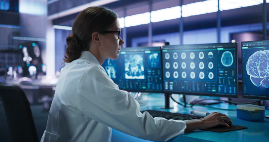 Hospital Research Laboratory: Female Medical Scientist Using Computer with Brain Scan MRI Images. Professional Neurologist Analysing CT Scan, Finding Treatment Solutions for Patient With Alzheimer's. Royalty-Free Stock Footage #1110879647