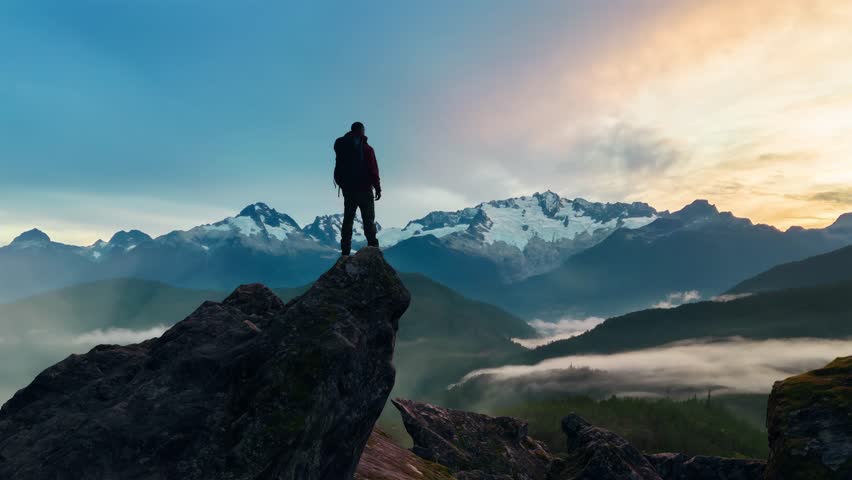 Epic Adventure Composite of Man Hiker on top of rocky mountain. Sunset Sky. 3d Rendering peak. Background landscape from North America. 
