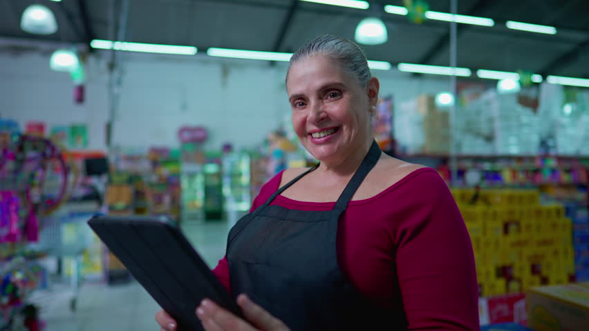 Portrait of one Middle-Aged Female employee of Supermarket Chain Joyful expression holding Tablet Device Royalty-Free Stock Footage #1110880705