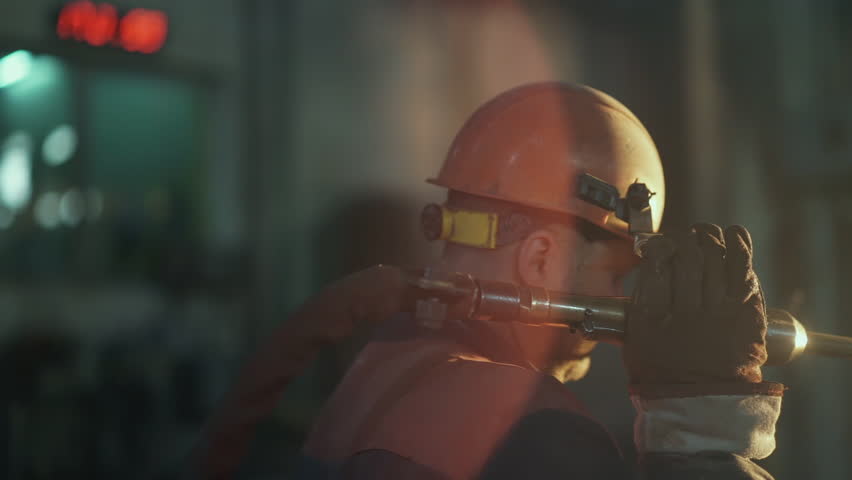 Camera Tracking the Rope or Cable Tilt Up to the Factory Man Working in the Plant of Metal Production. Welding, Casting, Foundry Light, Sparks. Metallurgy. Epic and Cinematic shot. Slow Motion | Shutterstock HD Video #1110882041
