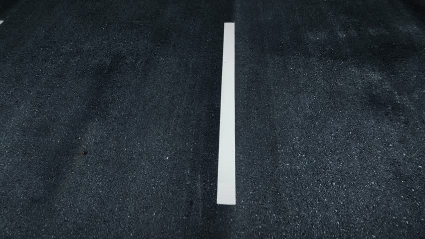 In the tender embrace of dawn, the virgin asphalt road whispers beneath the wheels of a moving car, a symphony of progress painted with tire imprints. Car and road background. POV view.
