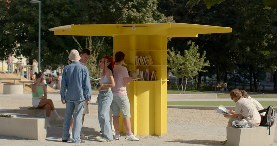 People rest in park, reading books. An open public library is community resource that provides access to wide range of books or reading materials for free. Open spaces for intellectual nourishment.
