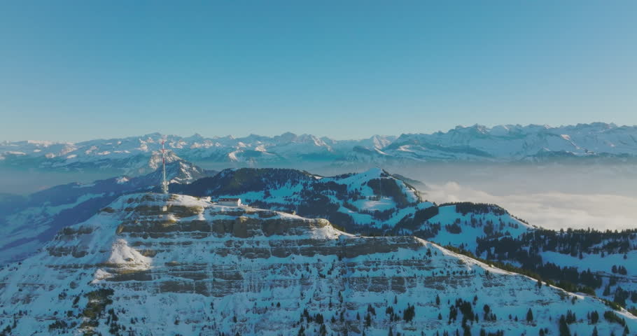 Telecommunications tower on top of Mount Rigi (Rigi Kulm) with amazing snow and fog covered Swiss alps mountain peaks and Lake Lucerne underneath in winter scenery landscape. Aerial drone. Switzerland | Shutterstock HD Video #1110899729