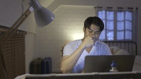 Young Asian man working overtime at home take medicine and drink water to relieve stress and headaches. - Powered by Shutterstock - Get 15% off with code: PIKWIZARD15