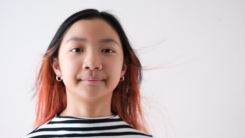 Asian teenage girl with fashionable hair color and eyeglasses looking or talking to camera via social media or video call with smiling face.