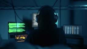 A hacker breaks into company data servers in dark atmosphere and has multiple displays. Hacker in dark room surrounded computers. Hacker breaks into corporate data server. Digital system security - Powered by Shutterstock - Get 15% off with code: PIKWIZARD15