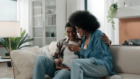 African American man guy reading book at home on sofa happy enthusiastic excited woman girl running into living room showing offer on phone mobile winning sharing good news couple smartphone success - Powered by Shutterstock - Get 15% off with code: PIKWIZARD15
