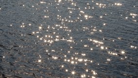 Sunbeams sparkling with star rays on the water. Seamless looped video