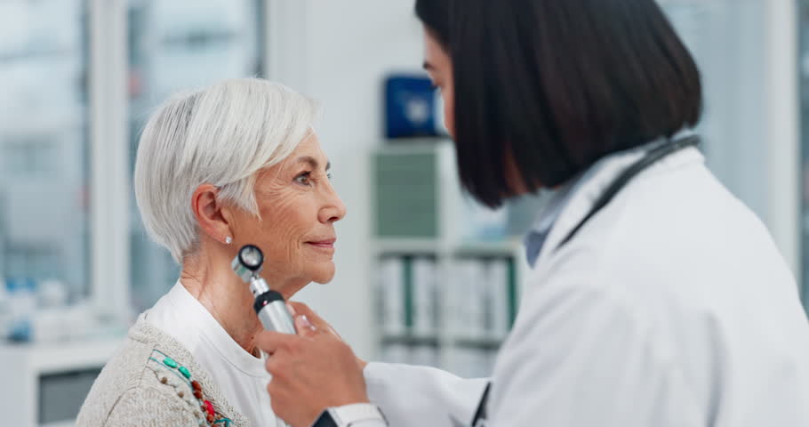 Senior woman, doctor and otoscope for ear, hearing test and exam, audio check or consultation for healthcare. Ent, otolaryngology and medical professional with elderly person for wellness in hospital