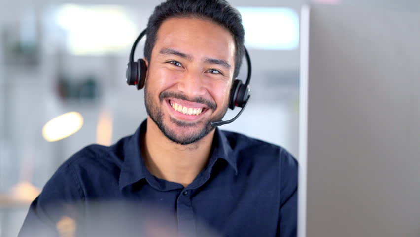 Laughing call centre agent helping customers while wearing a headset and typing on a computer to answer questions. Portrait of a friendly and cheerful male customer service operator in his office - Powered by Shutterstock - Get 15% off with code: PIKWIZARD15