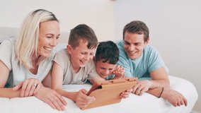 Kids, parents and tablet on bed for funny video, online games and relax together with home education or meme. Excited family, mother and father with children laughing on digital technology in bedroom