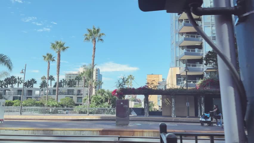 Tram ride Downton San Diego CA with Santa Fe Depot, buildings, palm trees, street