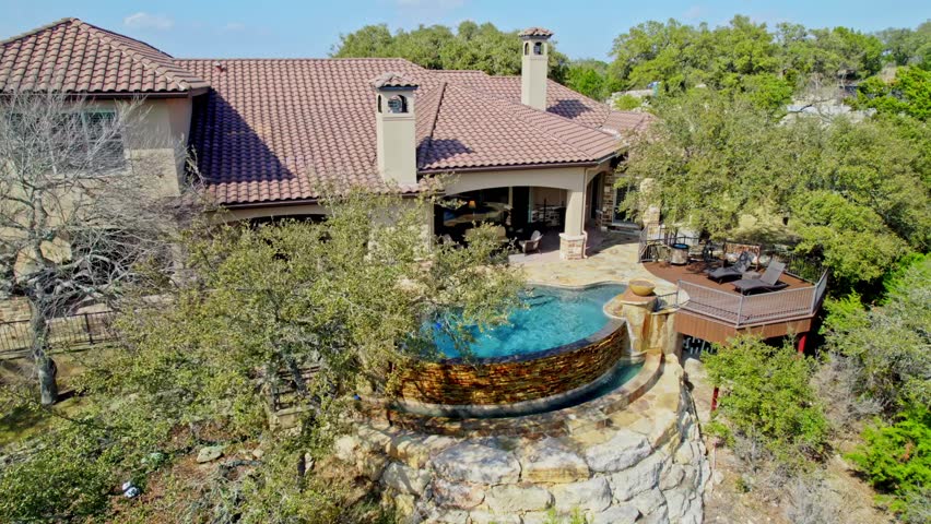 a home with a pool and a view from a hill 