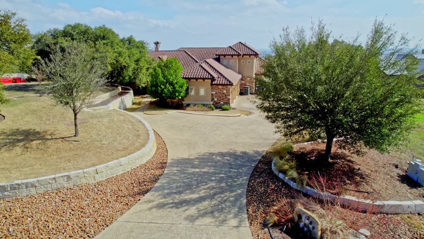 a home with a pool and a view from a hill 