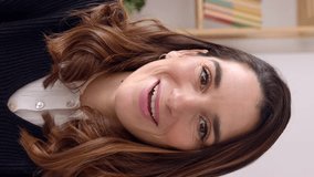 Vertical POV footage of young adult woman having an online video call talking to the camera at home office. Portrait of cheerful entrepreneur female during chat video conference. 