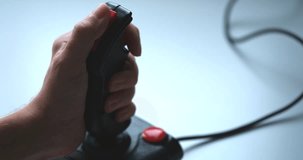 A man playing a video game with a retro joystick. Gaming joystick from the mid-1980s.