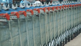empty shopping cart. supermarket or shopping center, mall. A supermarket employee or worker, wearing an orange vest, rolls empty shopping carts to the designated area. - Powered by Shutterstock - Get 15% off with code: PIKWIZARD15