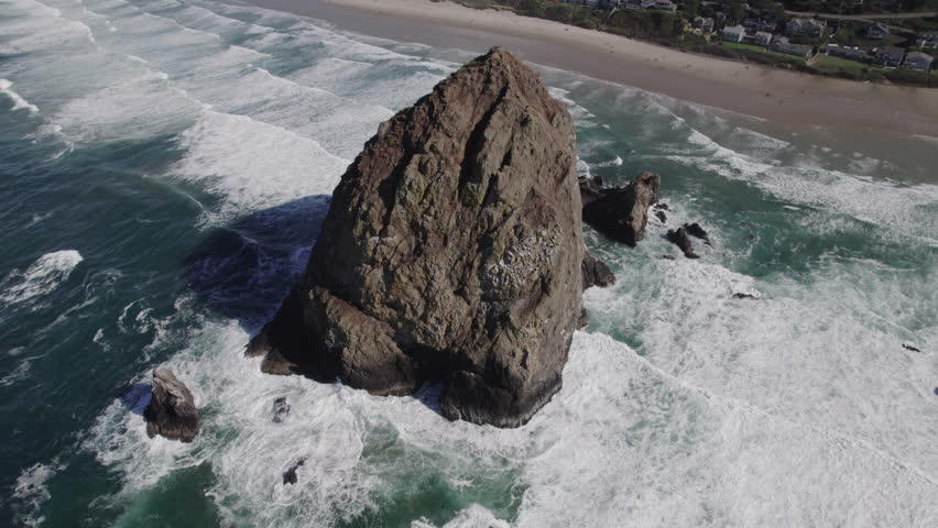 Huge rock protrudes from the water at Cannon Beach, Oregon