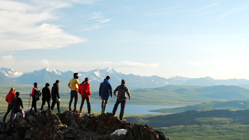 Group of hiker joy with travel success and together raise arms standing on top of high mountain at scenic view. Happy achievement in tourism and summit motivation Royalty-Free Stock Footage #1110954787