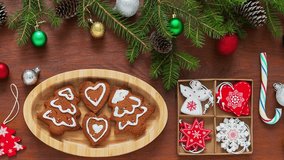 Merry Christmas and Happy New Year. Video of homemade Christmas cookies in shape of X-mas trees and hearts in wooden plate and fresh tangerines. Christmas tree branches, New Year toys on wood table