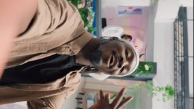 Vertical video Man filming POV vlog while doing shopping in elegant fashion boutique, giving viewers info. Influencer doing social media content in clothing store, promoting clothing store new - Powered by Shutterstock - Get 15% off with code: PIKWIZARD15