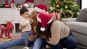 Couple and son sitting on floor by christmas tree playing at home - Powered by Shutterstock - Get 15% off with code: PIKWIZARD15